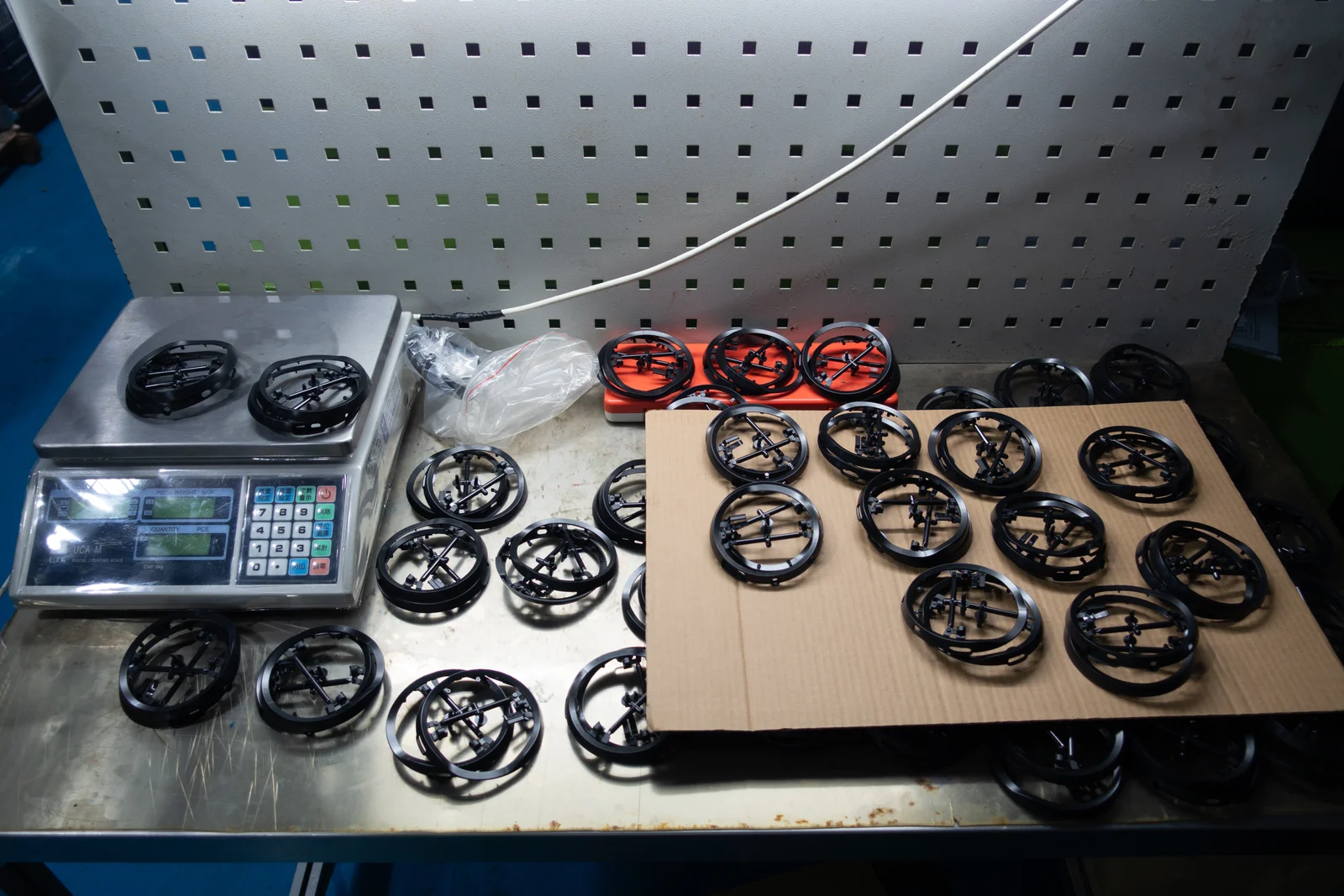 Trial parts and the weighing setup at a press-side QC station.