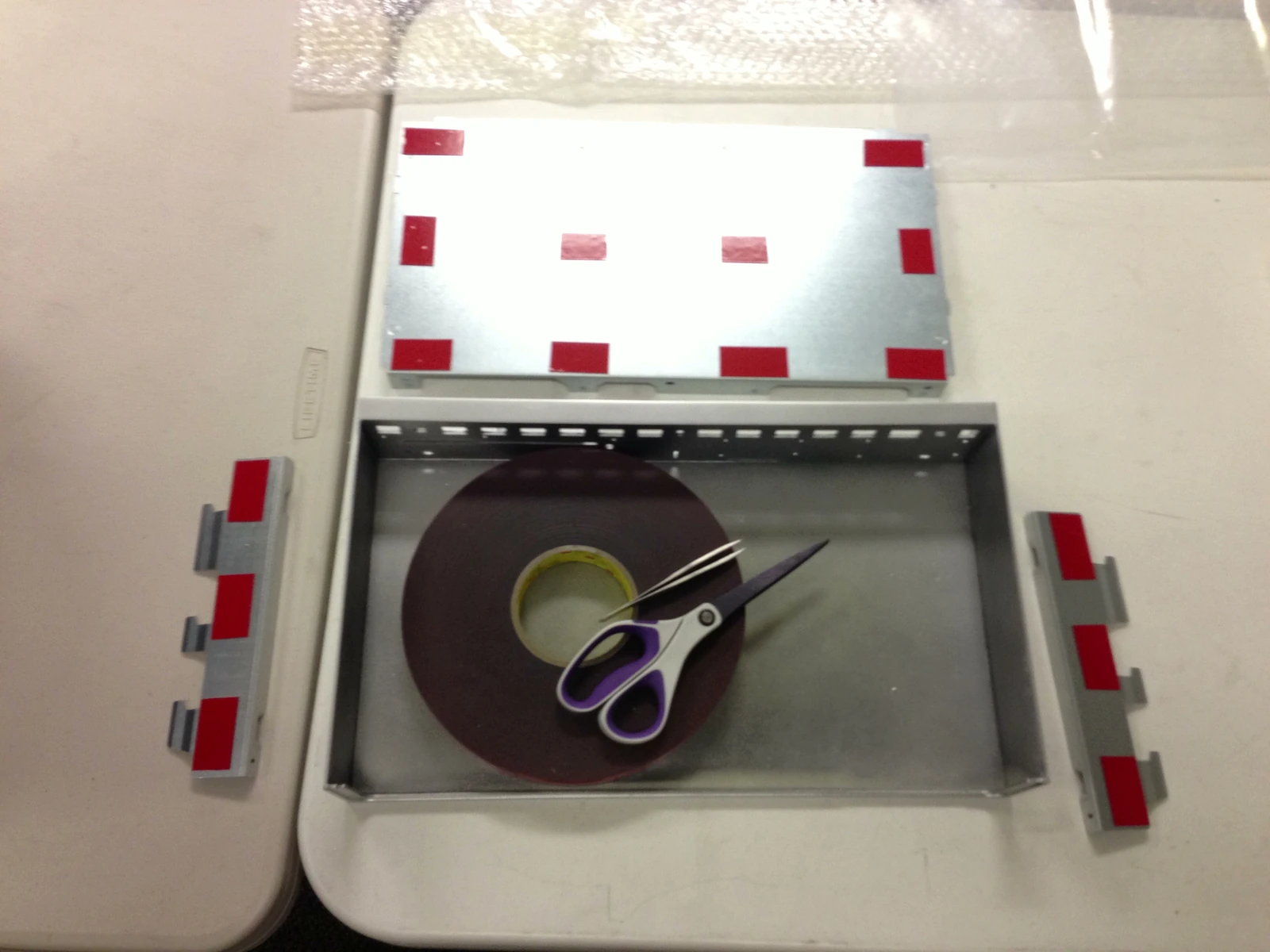 Cover, metal panels and tape laid out for assembly