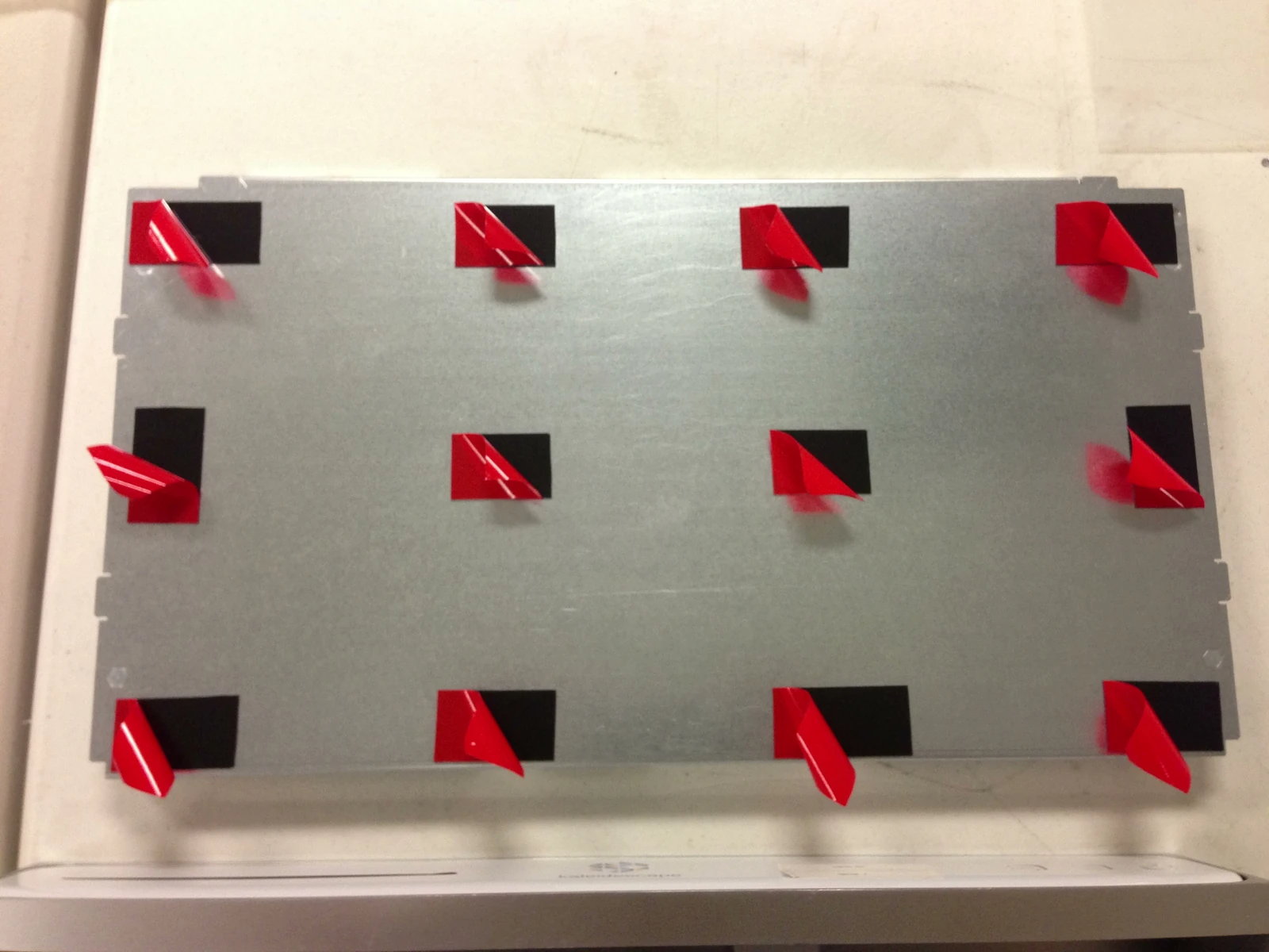 Adhesive liners partly peeled from the large metal panel